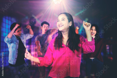 Picture of four young people enjoying a party while dancing together in the nightclub
