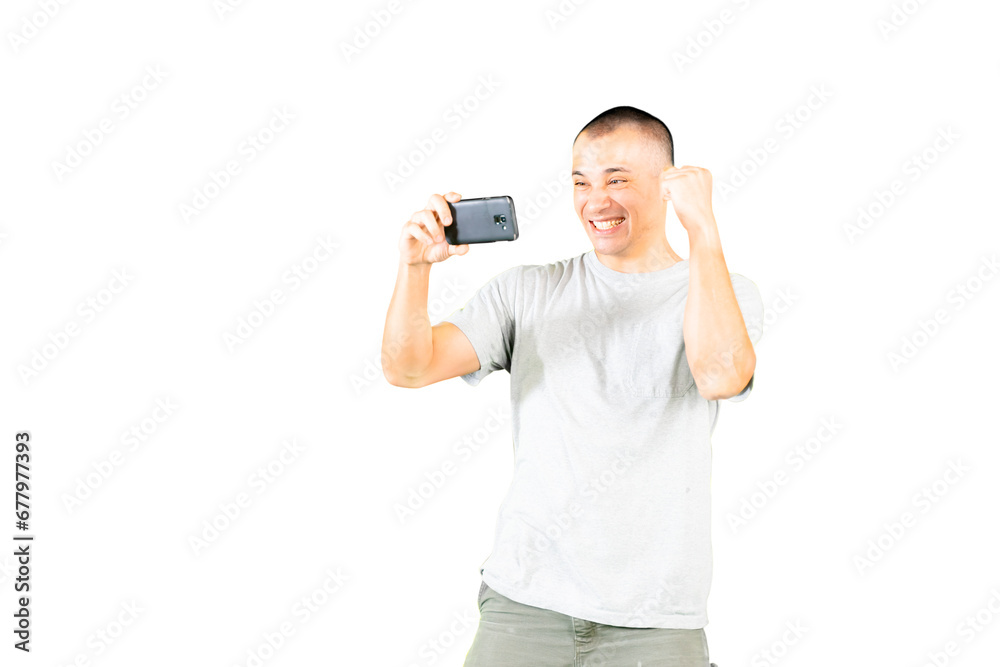 Happy bald caucasian handsome guy holding a mobile phone and showing winning gesture