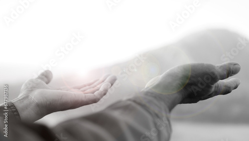 Hands receive lights in black and white background. Hand reaching out. Hope and faith, spiritual backgrounds concept. Receiving blessings. Surrender to God concepts. photo
