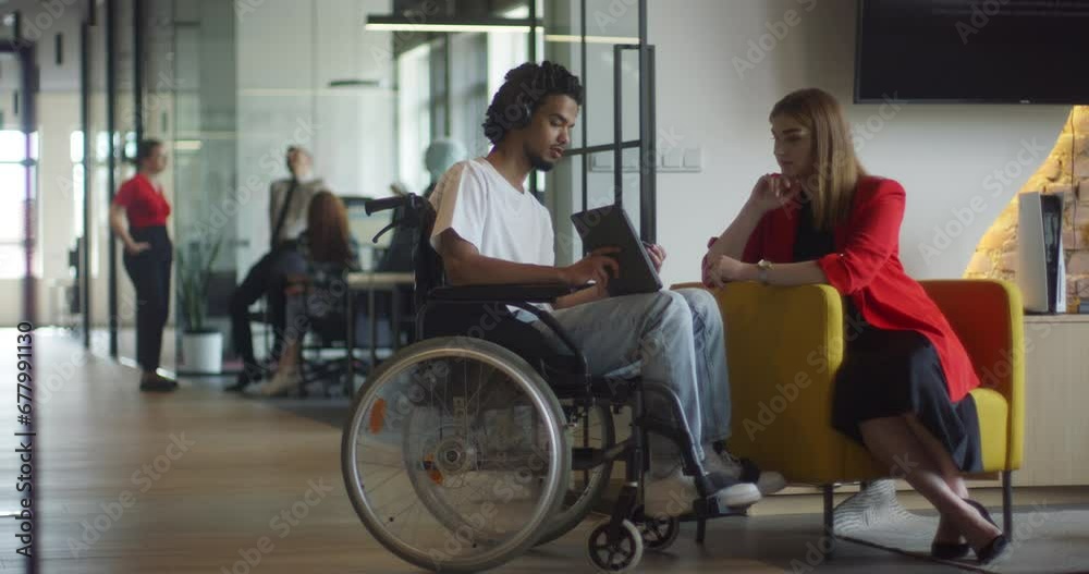 African American businessman in a wheelchair engages in a professional discussion with his colleague, addressing various business challenges and exploring solutions in an inclusive and diverse modern