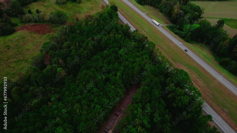 Semi-truck on forest-lined road, aerial view captures the essence of rural transport. Alabama USA Semi-truck on forest-lined road, aerial view captures the essence of rural transport. Alabama USA