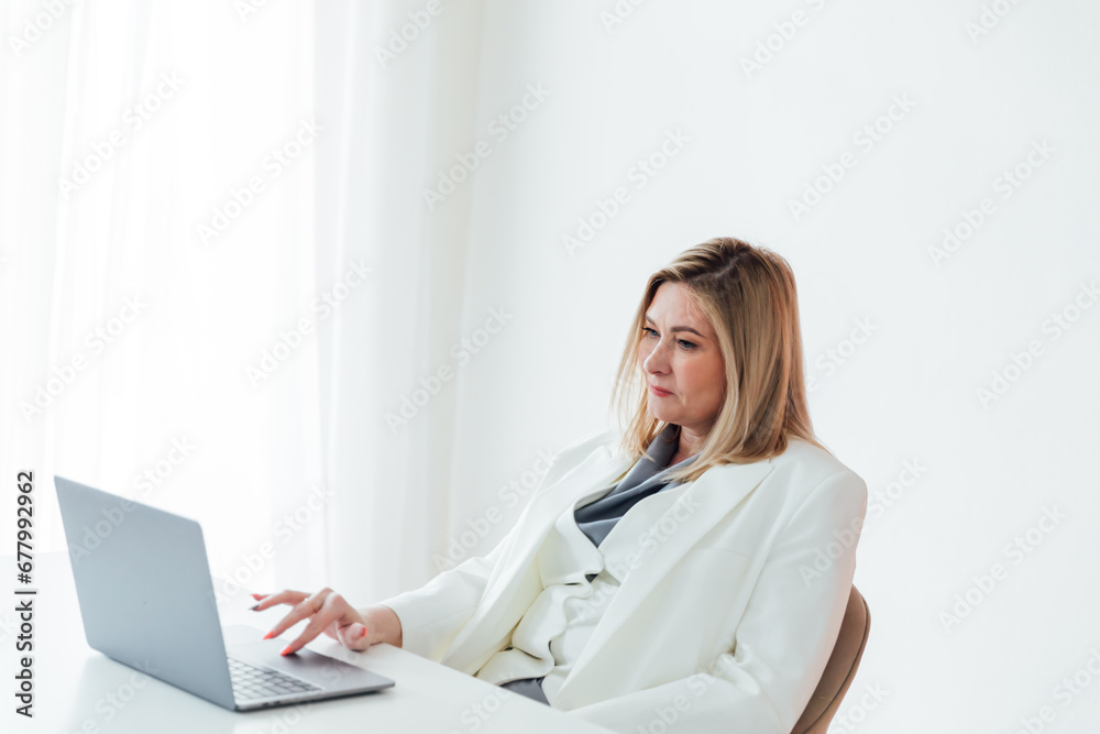 40s mid age European business woman CEO using laptop application for work sitting at table workspace in office. 40s mid age European business woman CEO using laptop application for work sitting at table workspace in office.