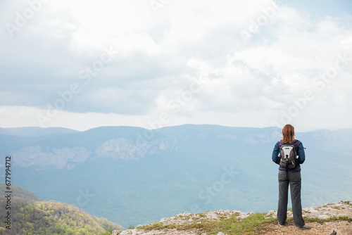 Traveler on top of mountain looking at landscape on hike
