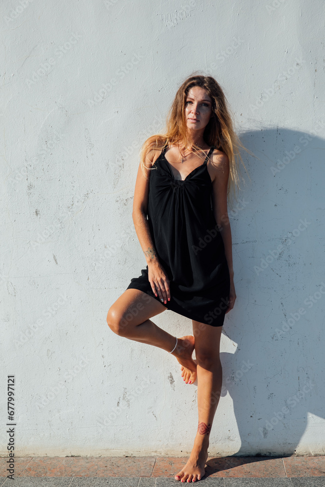 Fototapeta premium Beautiful slender woman in black summer dress