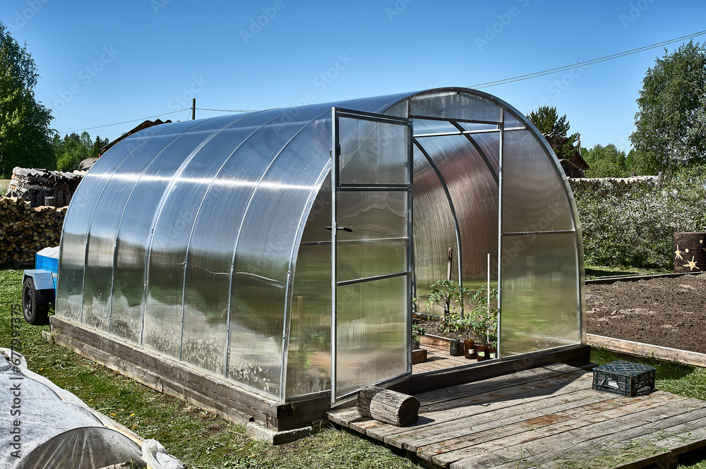A polycarbonate greenhouse stands on the plot A polycarbonate greenhouse stands on the plot