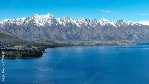 Fototapeta Naklejka Na Ścianę i Meble -  Drone panoramic view of the bays and inlets at Queenstown town at the southern end of Lake Wakatipu with a backdrop of the snow capped Remarkables Mountain range
