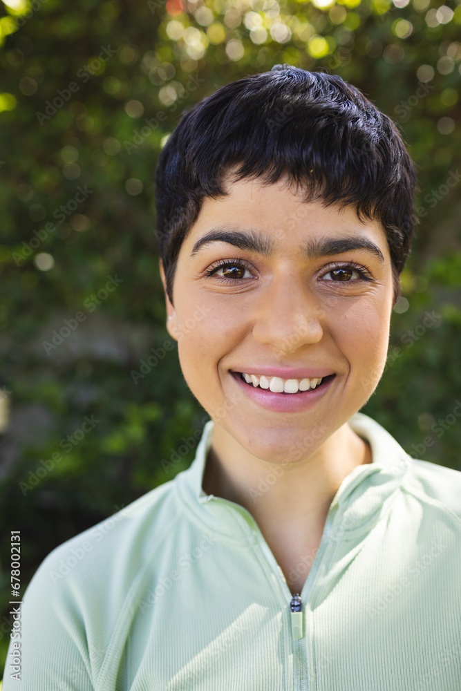 Portrait of happy biracial woman with short dark hair smiling in sunny garden Portrait of happy biracial woman with short dark hair smiling in sunny garden