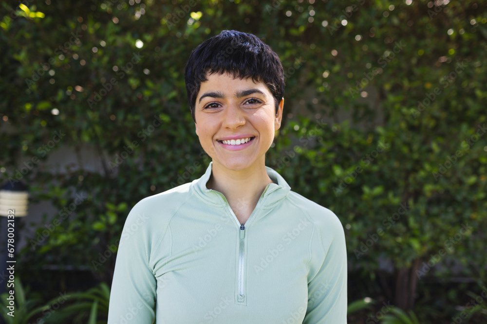 Portrait of happy biracial woman with short dark hair smiling in sunny garden Portrait of happy biracial woman with short dark hair smiling in sunny garden