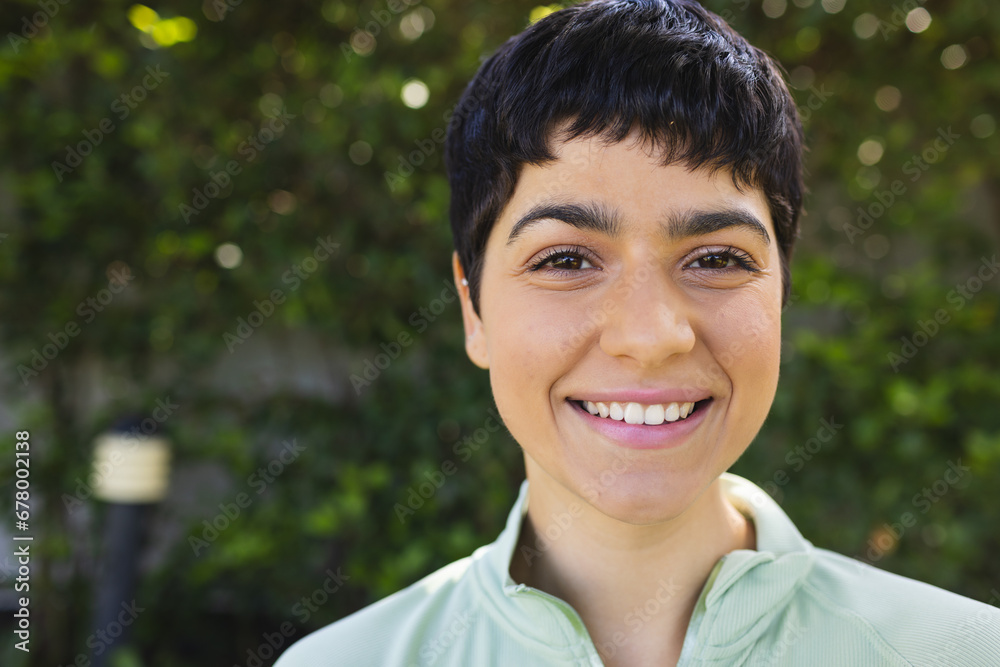 Portrait of happy biracial woman with short dark hair smiling in sunny garden Portrait of happy biracial woman with short dark hair smiling in sunny garden