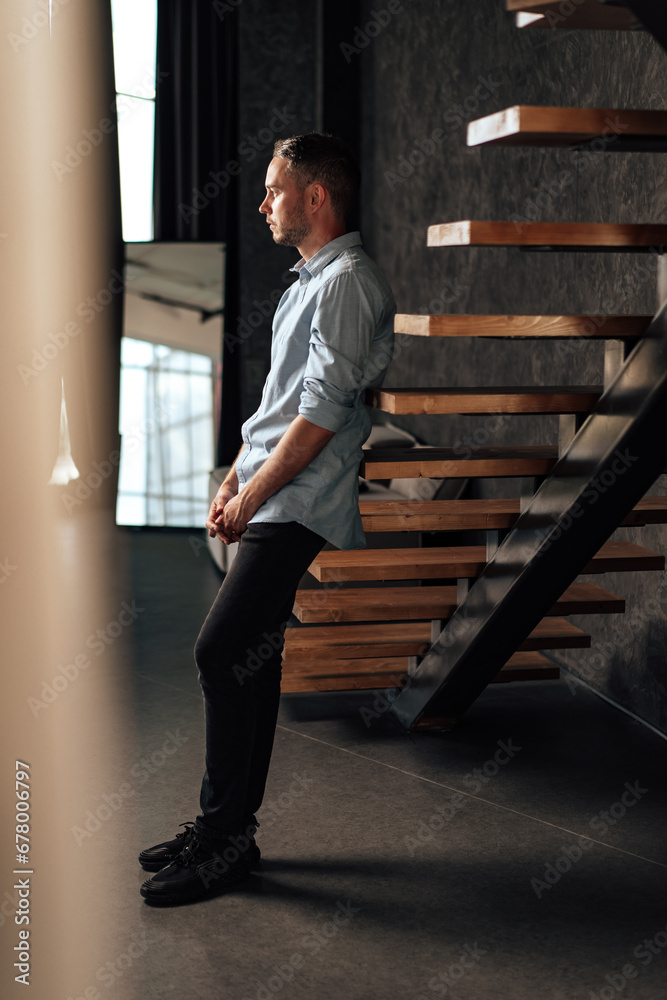 Confident young businessman standing near wooden ladder portrait Confident young businessman standing near wooden ladder portrait