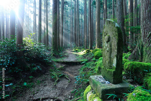 Jizo and shaft of light Kumano Kodo , Shingu, Wakayama,Wakayama Prefecture,Japan September 2013 photo