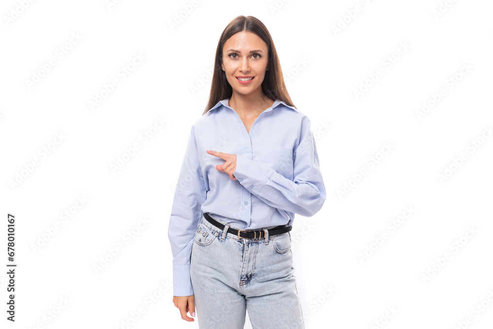young pretty european business lady with long black hair dressed in a blue blouse points her hand to the side on a white background with copy space young pretty european business lady with long black hair dressed in a blue blouse points her hand to the side on a white background with copy space