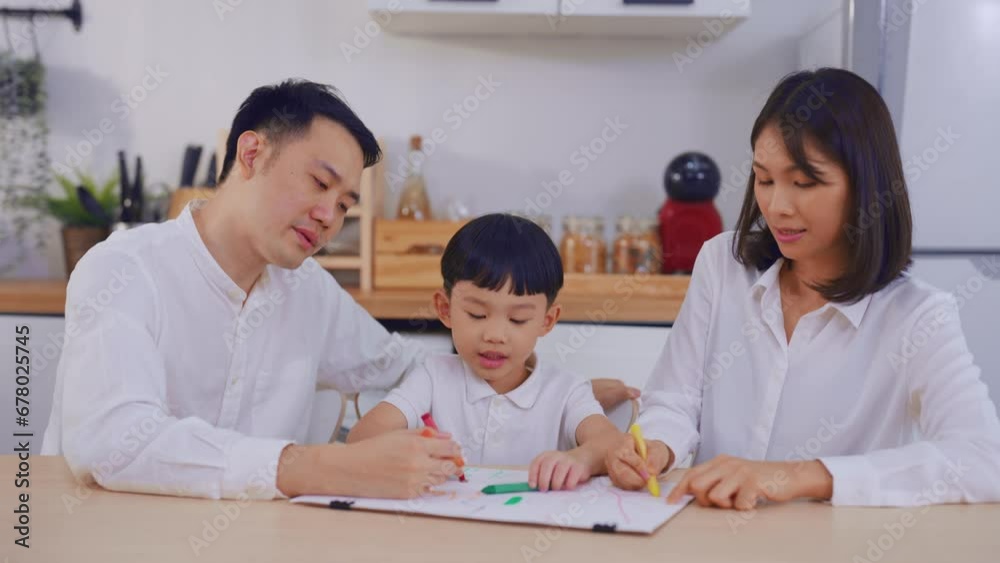 Adorable Asian young son draw picture on paper with parents in house. Adorable Asian young son draw picture on paper with parents in house.
