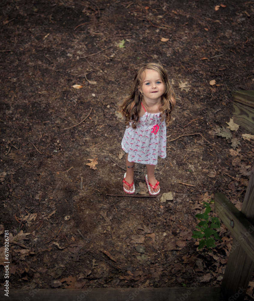 Beautiful little girl standing alone in forest Beautiful little girl standing alone in forest