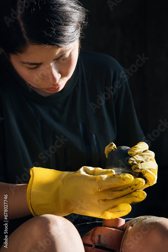 A woman polishes a stone with a special tool, close-up