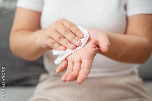 Woman wipes cleaning her hand with a tissue paper towel. Healthcare and medical concept.