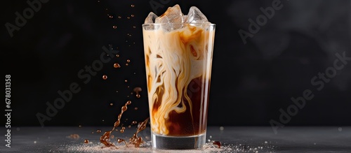 Cream being poured into cold coffee in a tall glass showcasing the drink s texture on a light gray background Copy space image Place for adding text or design photo