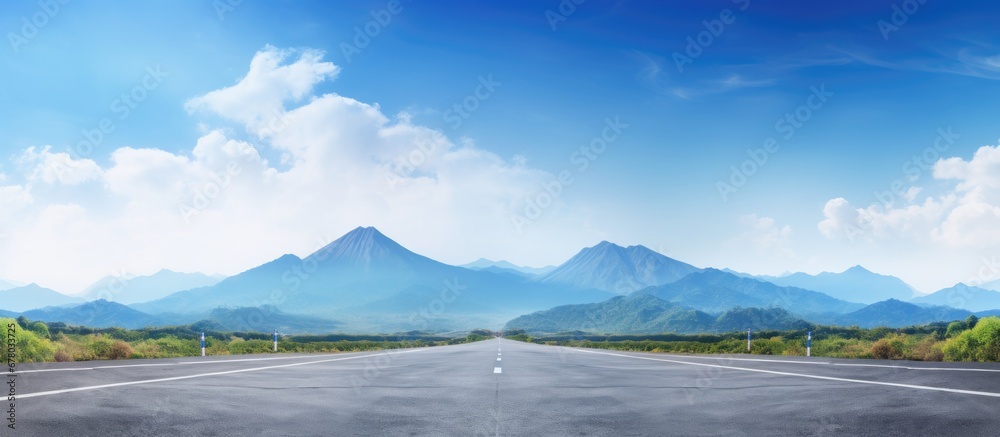 Desolate road with mountain landscape and blue sky Copy space image Place for adding text or design