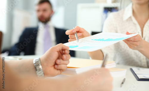 Close-up of smart female explaining different complicated details of important business document or strategy that determine future of colossal corporation. Company meeting concept