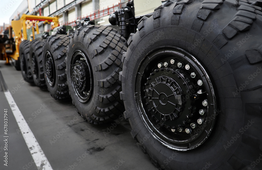 Heavy wheeled tires tractor on assembly line of the plant for transport non-standard cargo unusual background Heavy wheeled tires tractor on assembly line of the plant for transport non-standard cargo unusual background