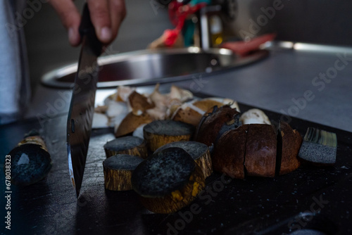Wild edible mushrooms being cut by knife on cutting board