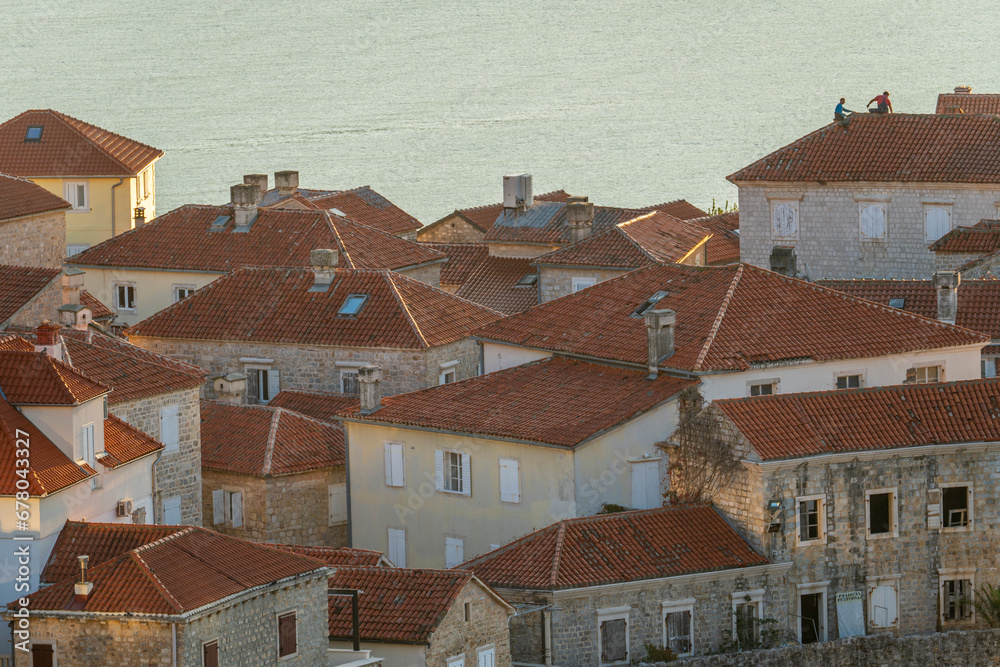 Montenegro Budva city old town red tiled roofs church tower and blue sea mountains in the background Montenegro Budva city old town red tiled roofs church tower and blue sea mountains in the background