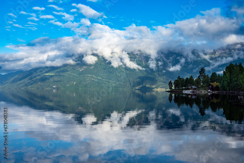 Clouds and mountains reflecting on fjord in Norway