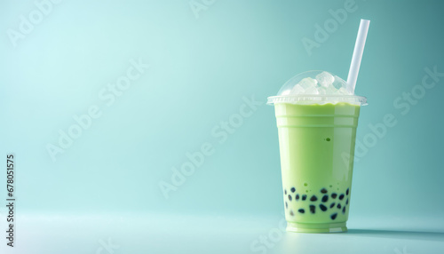 Green matcha bubble tea with ice cubes in cup on blue background. Antioxidant and dietary vegan cocktail for healthy breakfast or snack. photo