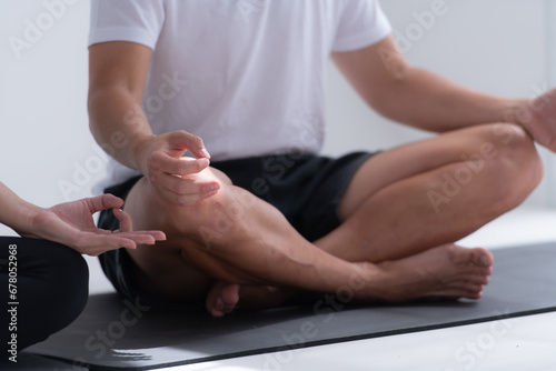 Young couple meditating in lotus pose on exercise mat at home, Yoga exercise concept