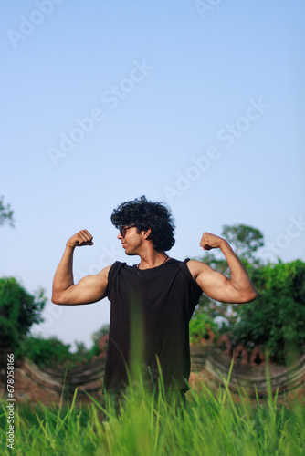 Fashion shoot of a handsome and sexy indian or arab looking male fitness model with a gym fit body and black curly hair and clean shaved posing. 