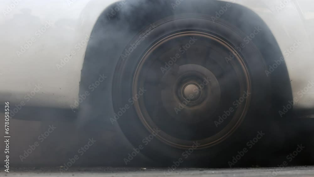 Drag car burning tire, Warm up tire before competition, Drag car wheel, Spinning wheel and smoke, Drag racing car burns rubber tires preparation for race. Drag car burning tire, Warm up tire before competition, Drag car wheel, Spinning wheel and smoke, Drag racing car burns rubber tires preparation for race.