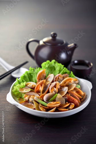 traditional chinese wok fried seafood fresh clam Lala with spicy chilli sauce in plate on grey vintage background asian cafe hotel luxury halal food restaurant banquet menu
