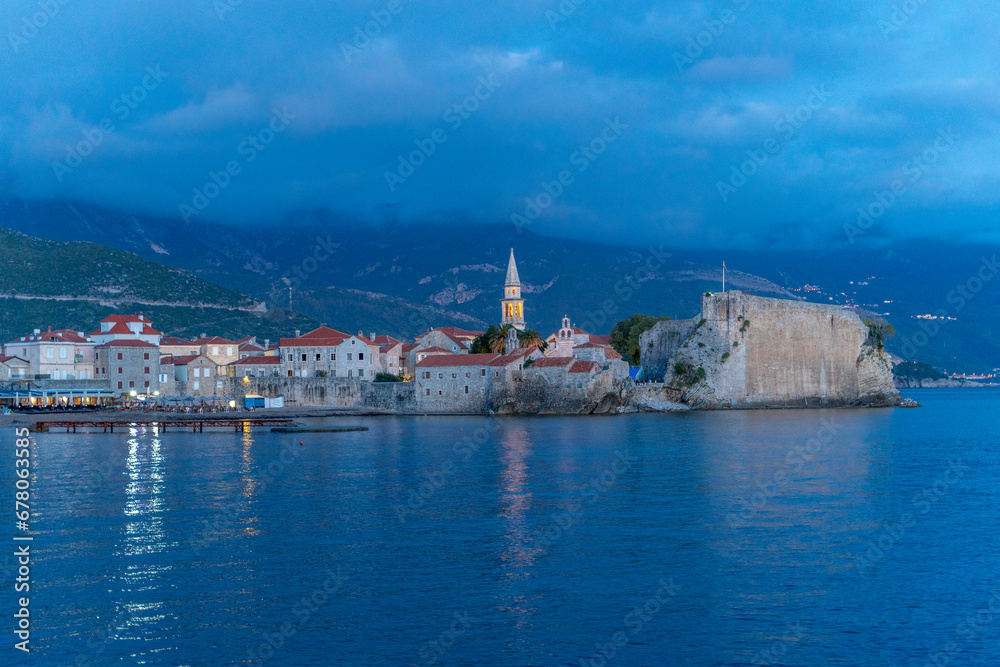 Montenegro Budva city old town red tiled roofs church tower and blue sea mountains in the background