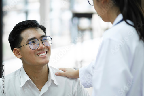 A happy young is smiling while his doctor is support him.