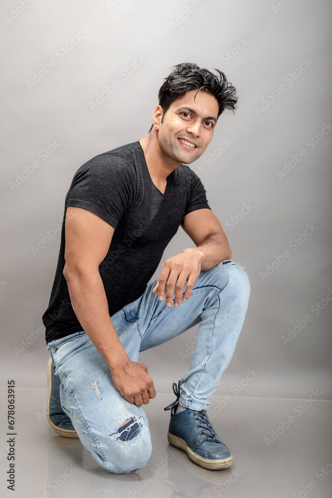 Indian young male model in casual wear wearing black tshirt and blue torn denim jeans. Male model. Fashion Portrait. Indian young male model in casual wear wearing black tshirt and blue torn denim jeans. Male model. Fashion Portrait.