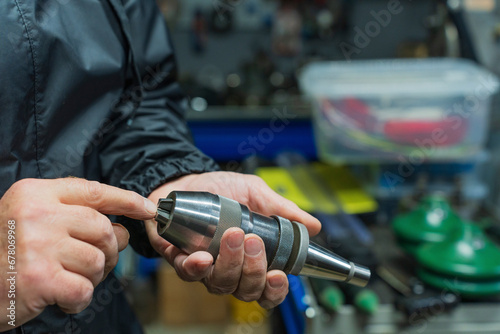Man with tools. Part of a drilling machine in the hands of a man. High quality photo
