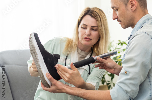 Female physiotherapist adjusting prosthetic leg of patient in hospital photo