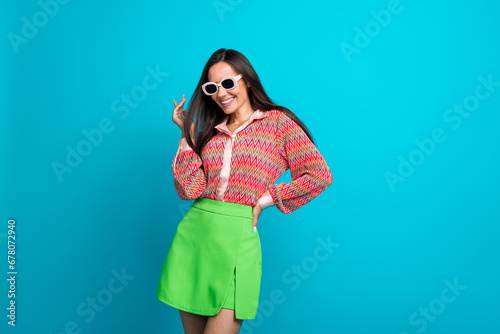 Portrait of nice cool young lady wearing sun specs glamour clothes visit youth party discotheque isolated teal blue color background