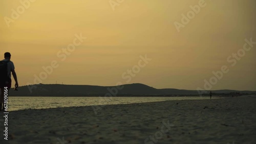 Couple Walking Along Shoreline In The Evening