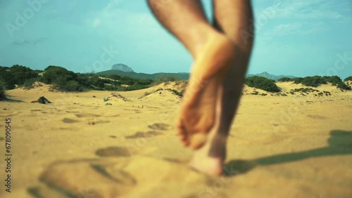 Close Up Of Man's Feet Walking On Golden Sand At The Beach