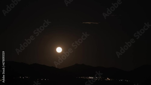 Time Lapse Of A Full Moon Rising Behind A Mountainside