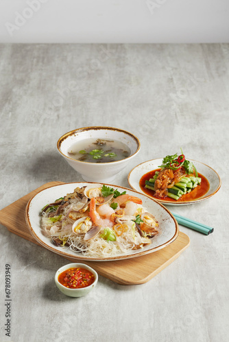 traditional chinese set seafood fried putian noodle with dumpling dim sum bao and soup snack vegetable in plate on grey vintage background cafe hotel luxury halal food restaurant banquet menu photo