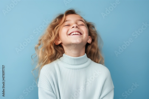 Medium shot portrait photography of a pleased child girl against a light blue background © Nate