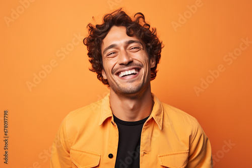 Medium shot portrait photography of a pleased man in his 30s against a light orange background © Nate