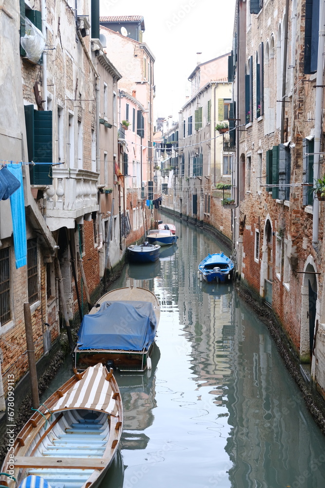 A vertical view of a small random canal in Venice. Italy - November 13, 2023.