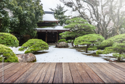 Wooden table top with blurred garden and japan house.