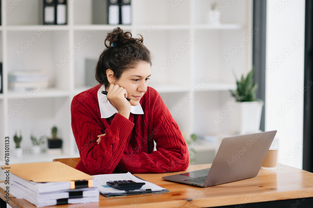 Beautiful woman using laptop and tablet while sitting at her working place. Concentrated .. Beautiful woman using laptop and tablet while sitting at her working place. Concentrated ..