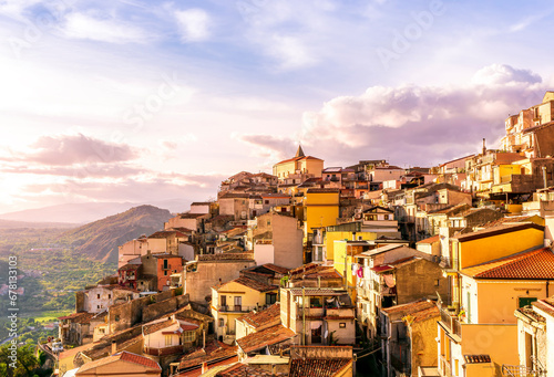 old vintage mediterranean mountain town with yellow and orange roofs, old tradirional streets, churches and amazing cloudy landscape on background photo