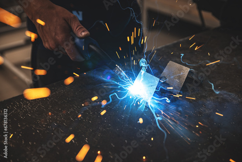 Male worker hand welding steel rack photo
