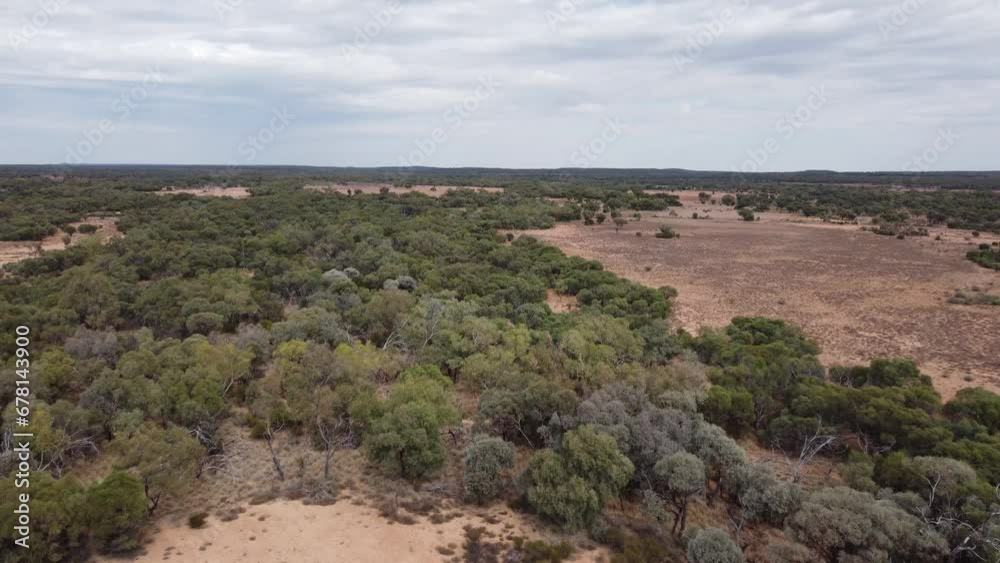 Aerial view of a remote Australian outback land with trees and bushes below Aerial view of a remote Australian outback land with trees and bushes below